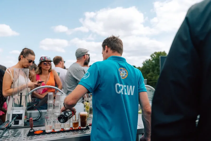 Crew-Mitglied an der Bordbar mit Gästen