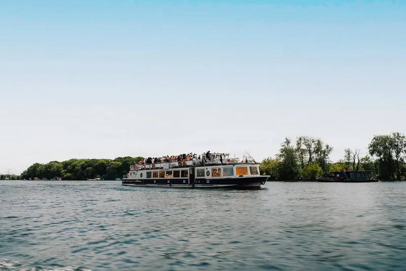 Eventschiff auf weitem Wasser mit grünem Ufer